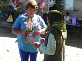 Глава сельсовета И. В. Сергеева вручает подарок старейшей жительнице поселка А.И.Шипичевой